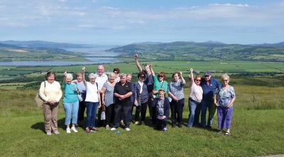 A Gathering in Donegal: Kerryman Mark Lyons, the bus driver assigned to Cardinal O’Malley’s pilgrimage tour to Knock last month, made this photo in Donegal at Grainan of Aileach ring fort overlooking Lough Swilly. Waving hello are pilgrims from New England who traveled through the Great Atlantic Way in Ireland’s northwest while on the island for the services at Knock.